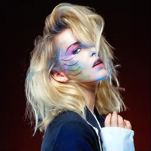 A high fashion editorial photograph showing a blonde with dramatic makeup