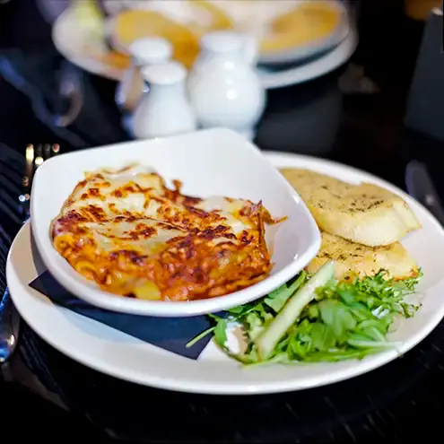 Food photography, commercial photograph, of a lasagne and salad