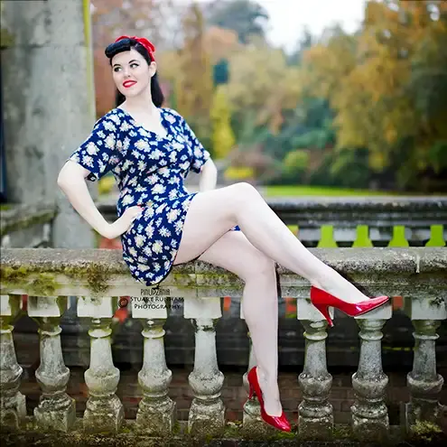 A long legged girl posing in a short dress outdoors, vintage style pinup