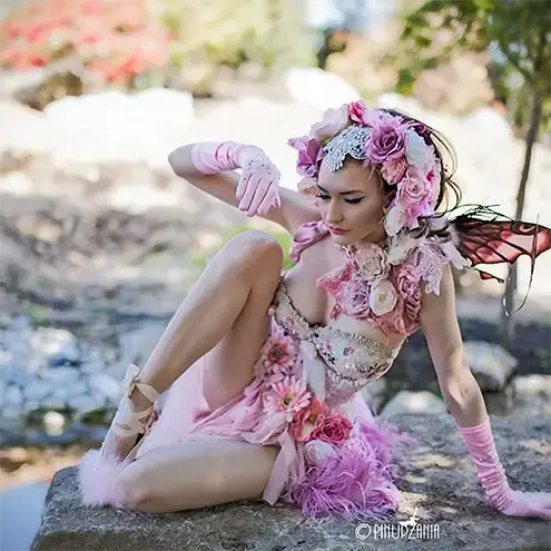 A beautiful burlesque fairy posing by a pond
