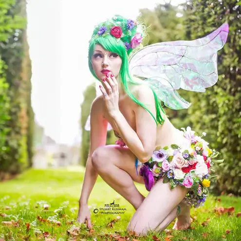 A burlesque fairy crouching outside