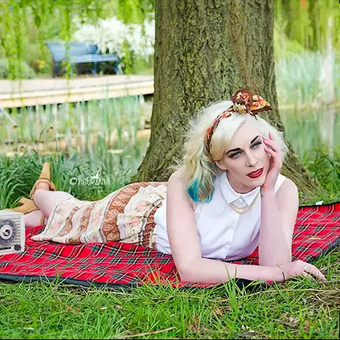 a vintage style pinup girl on a rug outdoors