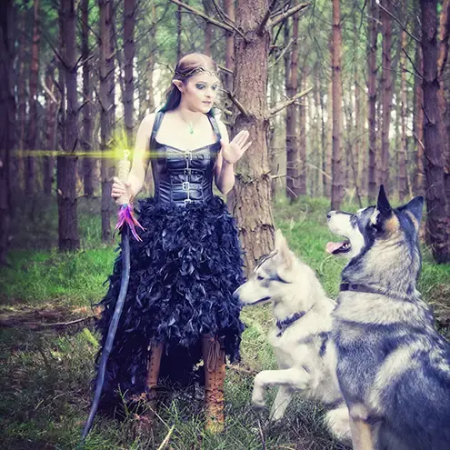 a female elf with 2 huskies in woodland