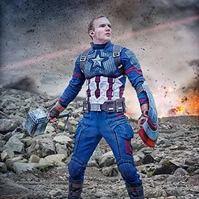 A high end cinematic composite image showing a cosplayer dressed as Captain America in a battle scene